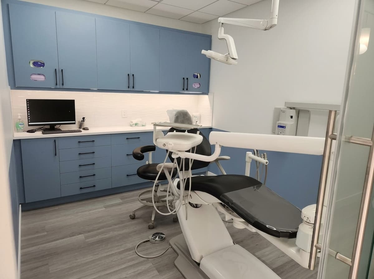 Schonsee Dental relaxed patient smiling during a checkup with dentist and assistant in Edmonton